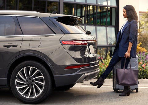 A woman with her hands full uses her foot to activate the hands-free liftgate. | Cavalier Lincoln in Chesapeake VA