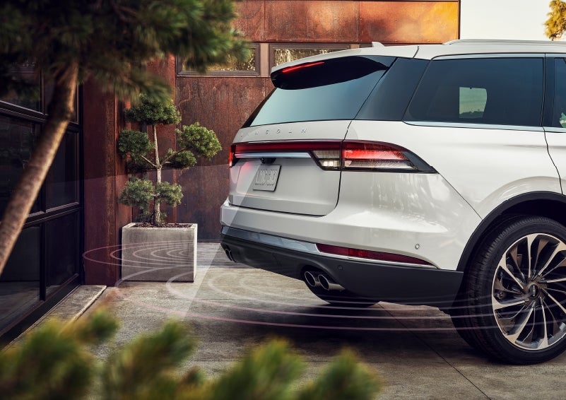 A 2022 Lincoln® Aviator as it is backing up close to a garage door while using rear back up sensors