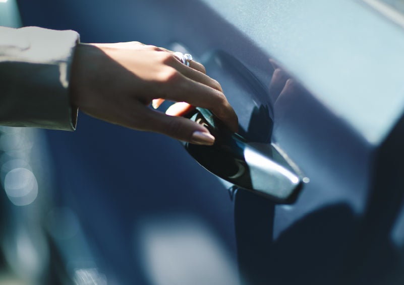 A hand gracefully grips the Light Touch Handle of a 2022 Lincoln® Aviator to demonstrate its ease of use