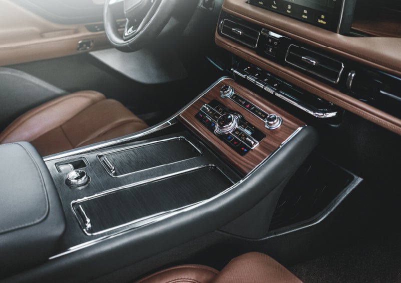 The front center console of a 2022 Lincoln® Aviator is shown to highlight aviationinspired materials used throughout the cabin