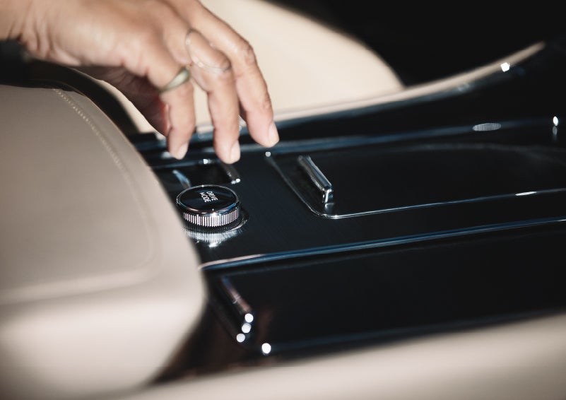 A hand reaching for the Lincoln® Drive Modes knob of a 2022 Lincoln® Aviator