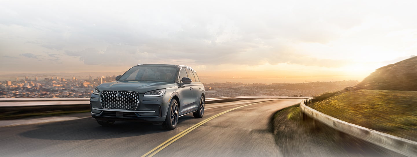 A Lincoln Corsair® Grand Touring model is shown being driven along a scenic roadway.