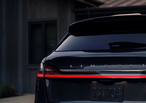 The rear of a 2023 Lincoln Nautilus® SUV is shown with rear taillamps illuminated.