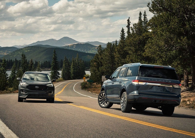 A 2023 Lincoln Navigator SUV is making a left turn as another vehicle approaches from the other lane. | Cavalier Lincoln in Chesapeake VA