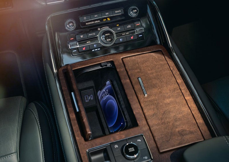 A smartphone is charging on the wireless charging pad* in the front center console cubby. | Cavalier Lincoln in Chesapeake VA
