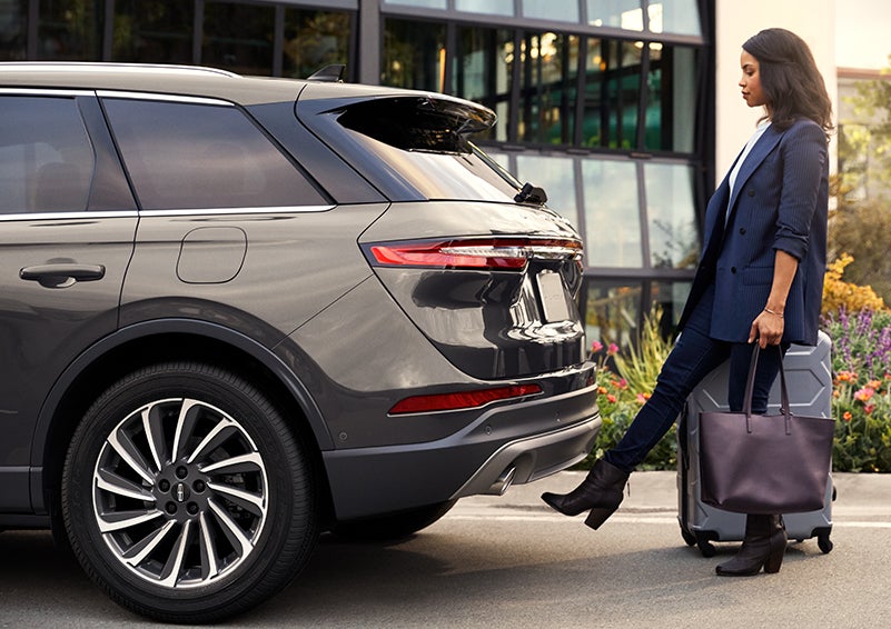 A woman with her hands full uses her foot to activate the available hands-free liftgate. | Cavalier Lincoln in Chesapeake VA
