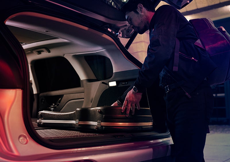 A man is shown loading cargo into the rear of a 2024 Lincoln Corsair® SUV with the second-row seats folded flat. | Cavalier Lincoln in Chesapeake VA