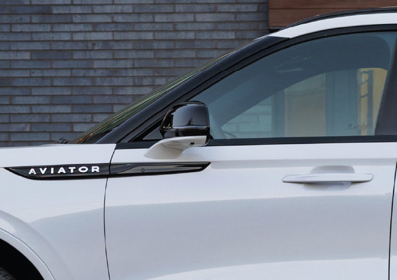 The driver’s side door and fender badging of a white 2026 Lincoln Aviator® SUV are showcased. | Cavalier Lincoln in Chesapeake VA