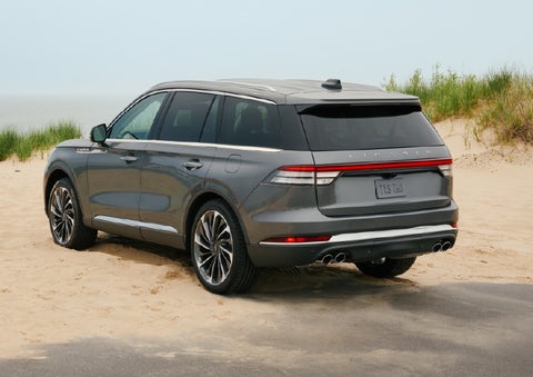 A 2027 Lincoln Aviator® SUV is parked next to sand dunes. | Cavalier Lincoln in Chesapeake VA