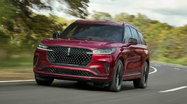 A 2027 Lincoln Aviator® SUV is being driven on a country road | Cavalier Lincoln in Chesapeake VA